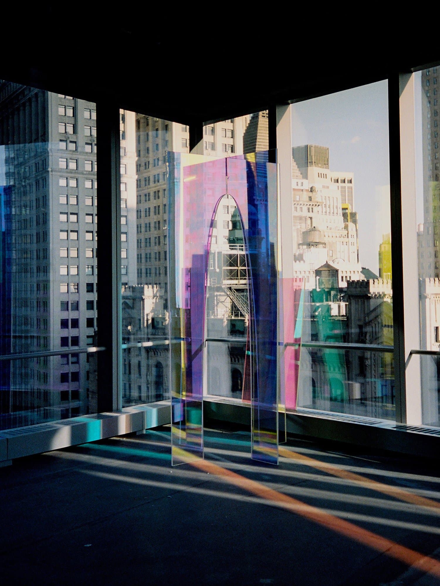 Marcus Manganni, Revolver, 2025. Translucent acrylic sculpture casting prismatic light against the Lower Manhattan skyline at Silver Art Studios, World Trade Center.